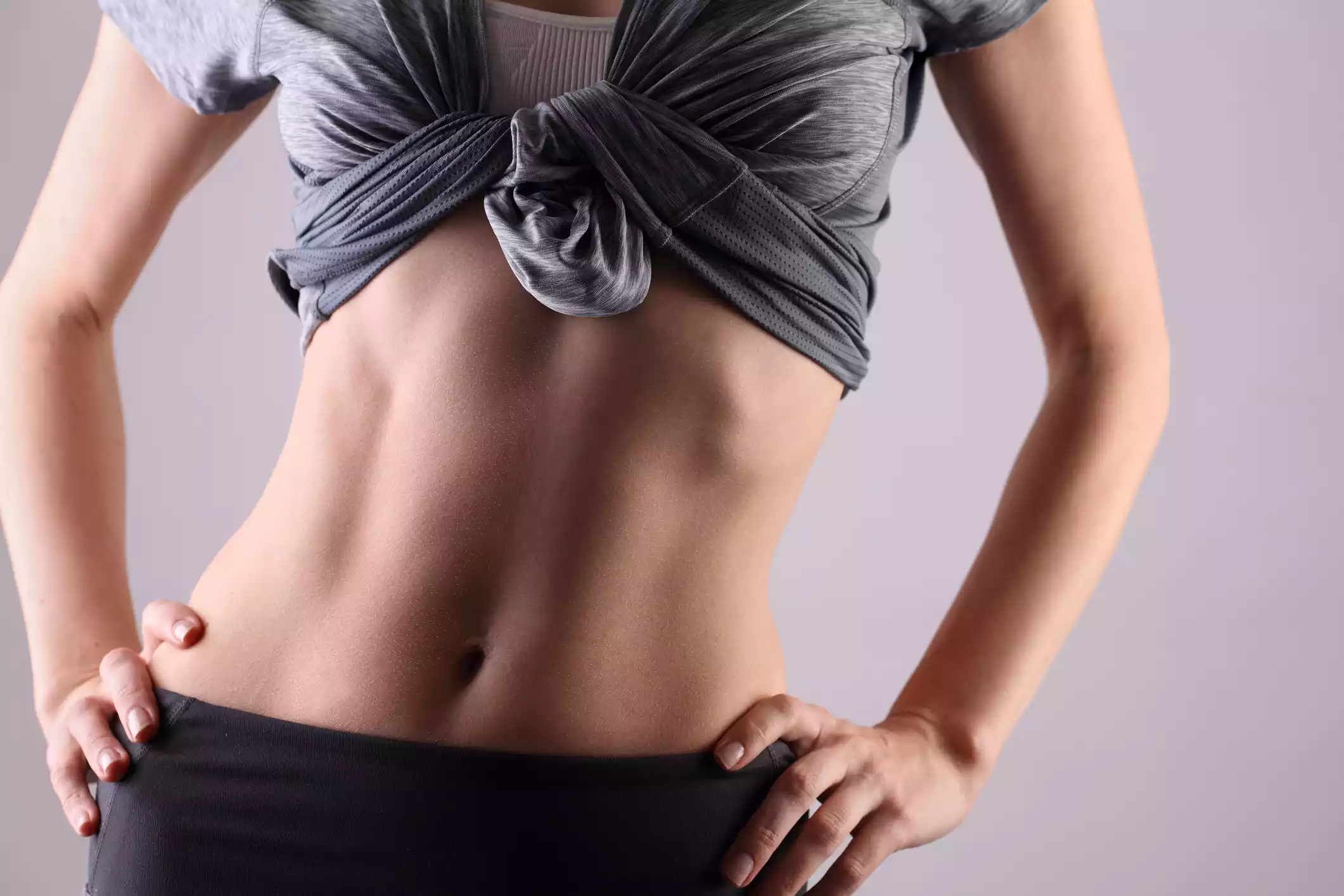 Fit woman showcasing toned abs after cosmetic body contouring in Gahanna